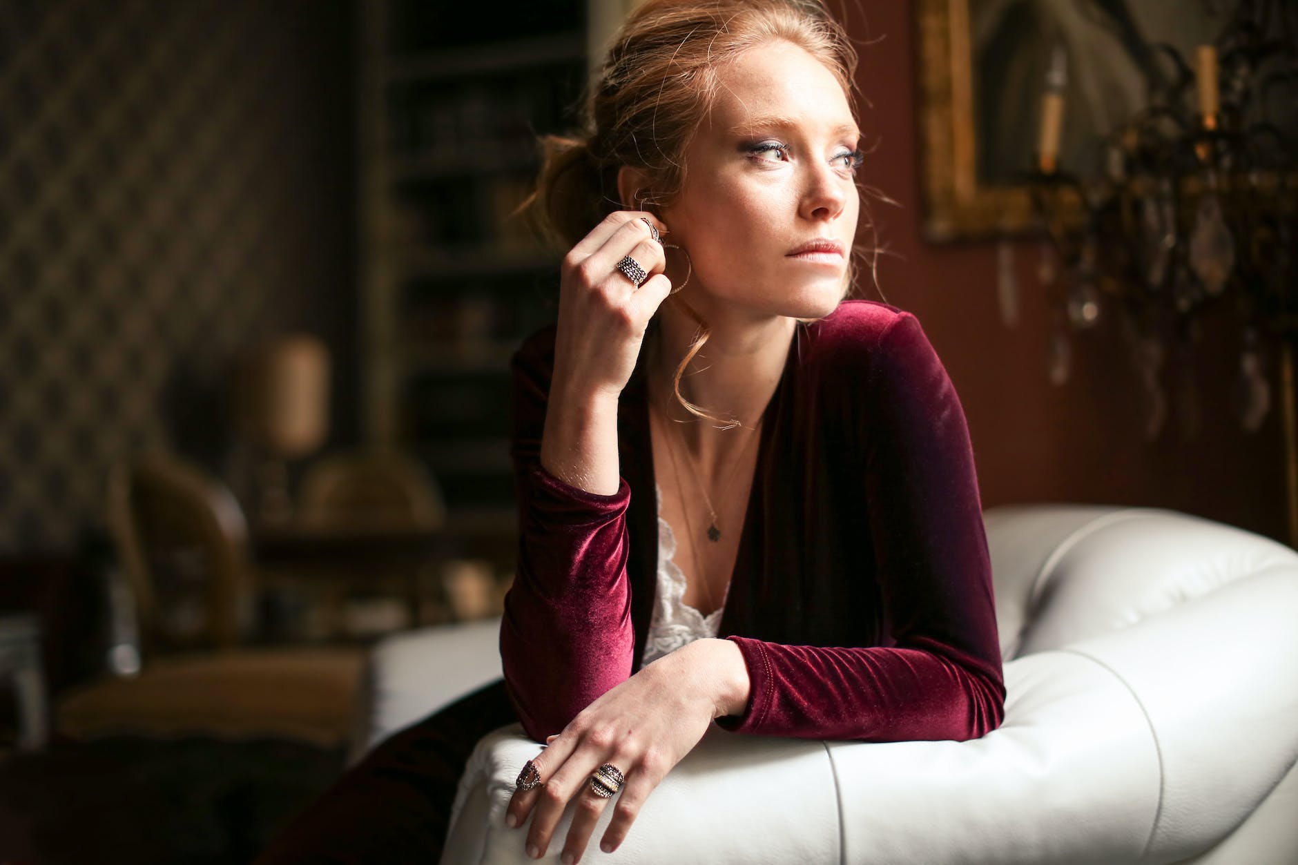 A woman sitting on white leather sofa with diamonds.